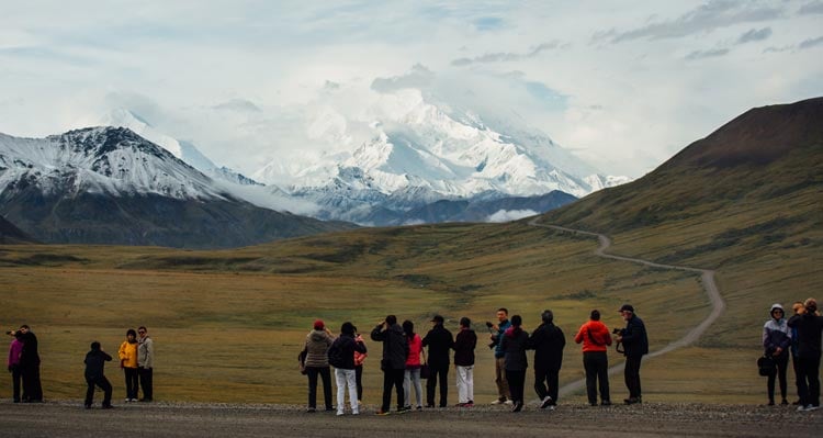 A crowd of people take photos of Denali from the Denali Park Road.