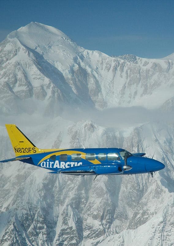 Flightseeing plane flying around snowy mountains in the Arctic Circle