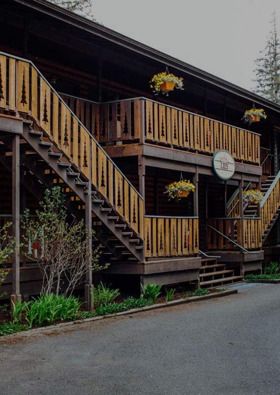 A wooden lodge with rustic decorative railings on staircases and balconies