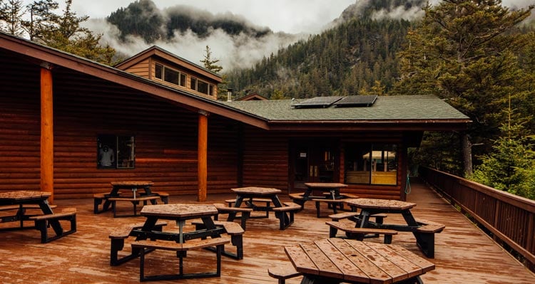 The deck at Kenai Fjords Wilderness Lodge with recently rained-on picnic tables