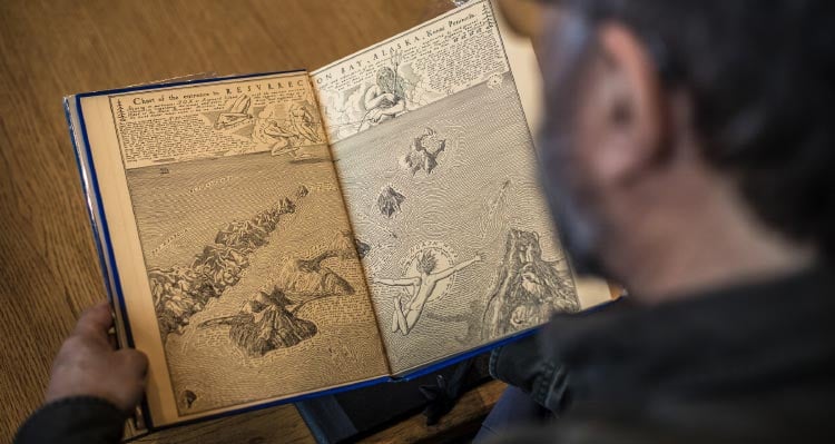 A view over a man's shoulder at an illustration of Resurrection Bay.