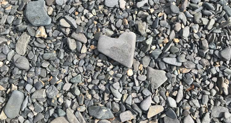 A heart-shaped rock among small pebbles.