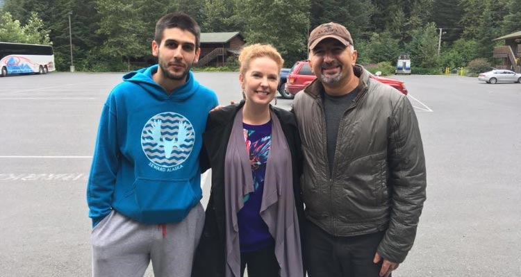 A group of three people smile for a photo.