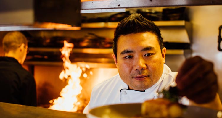 A chef puts the finishing touches on a plate of food, ready to be served.