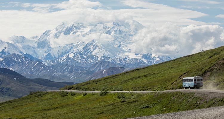 A bus drives along a mountainside road.