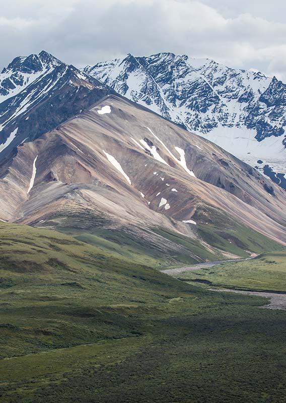 Mountains rise above a tundra valley and river.