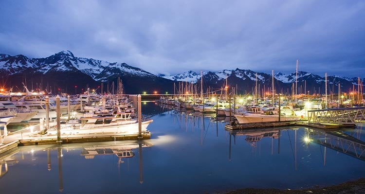 The Seward Harbor at dusk showing boats all lit up at the docks.