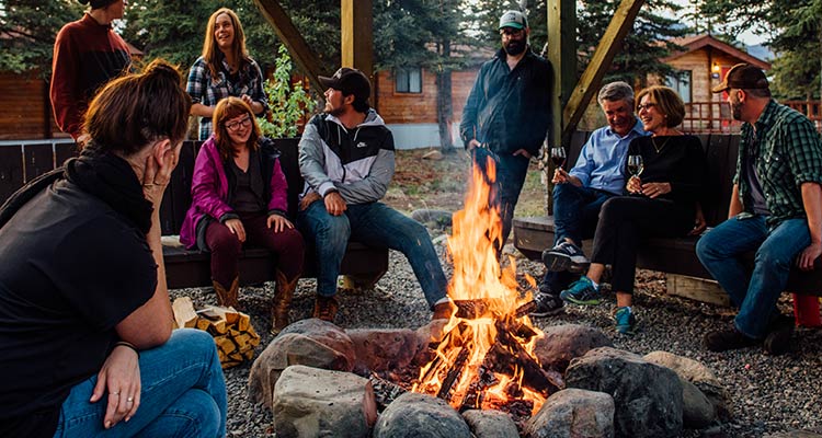 A group of people sit around a fire pit