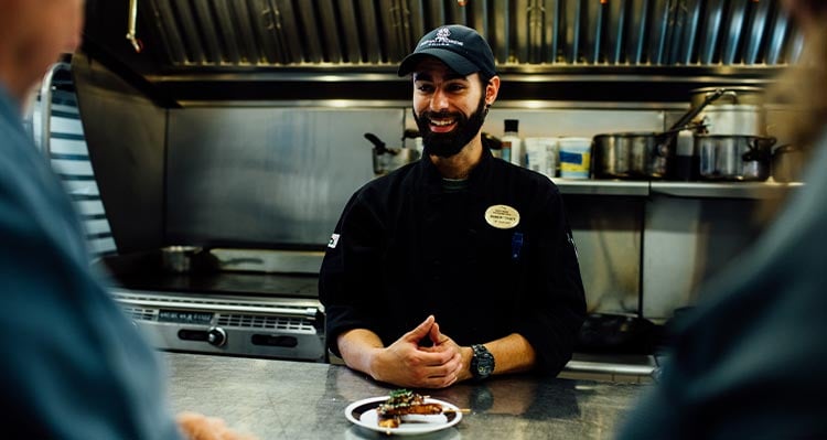 A chef prepares a plate of food in a kitchen.