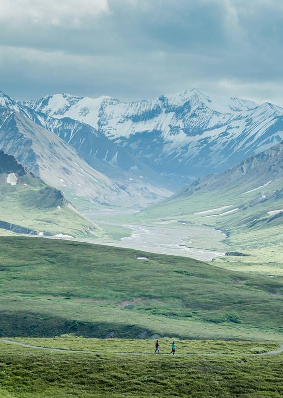 Two people walking in a valley in Denali National Park and Preserve