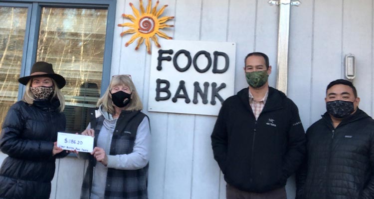 Four people stand outside a Food Bank.