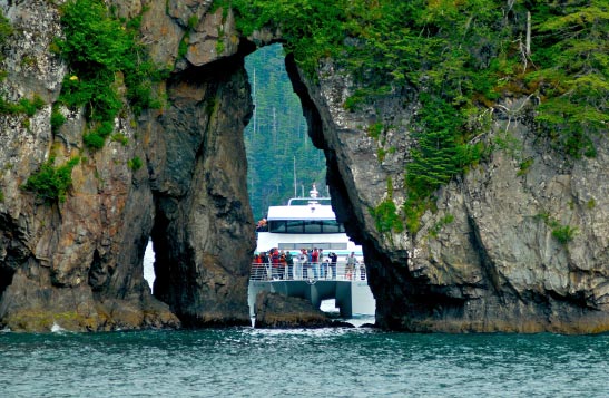 A boat framed between large overgrown cliffsides.