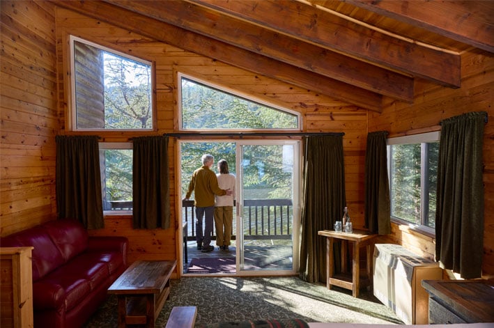 A couple standing on the outside balcony of the Lagoon Cabin