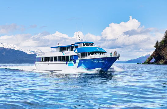KFT Nunatak boat sailing past mountains and an island