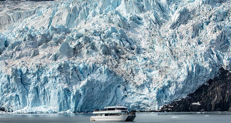 A tour boat below a large tidewater glacier.