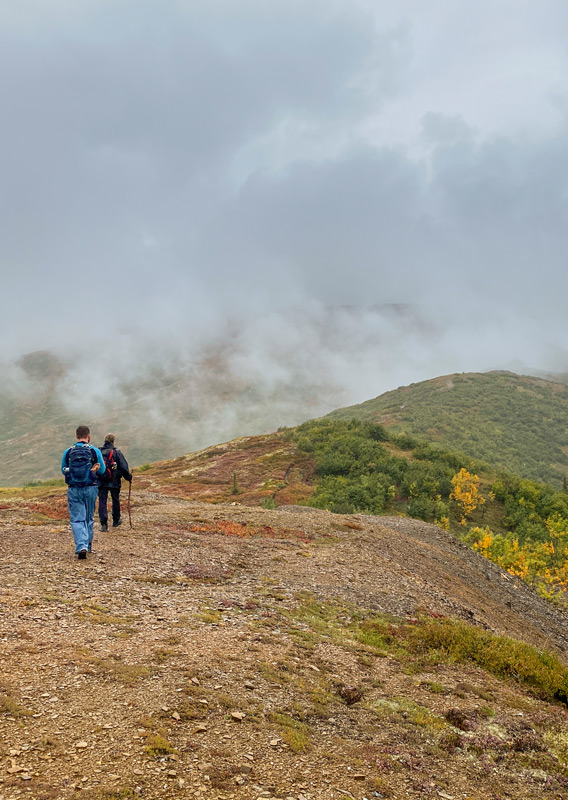 A couple hiking along a mountain trail in Denali