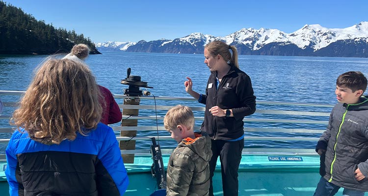 A tour guide shows some scientific equipment.