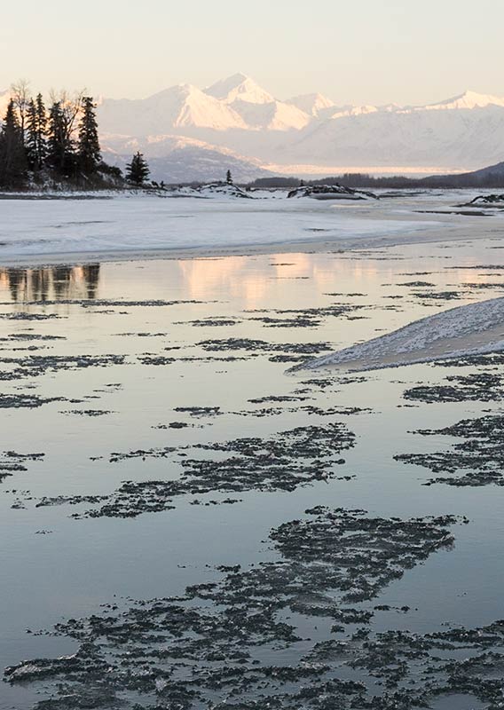 Icy water in Alaska, with mountains in the background.