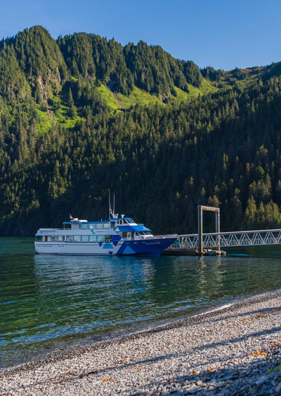 A Kenai Fjords Tours boat docked at Fox Island