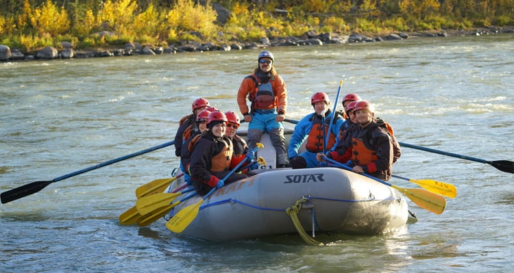 A group of people whitewater rafting