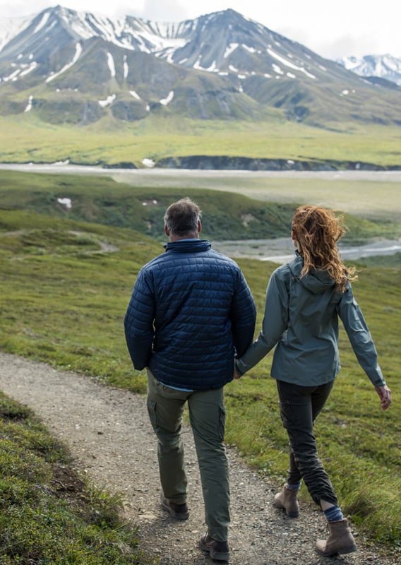A couple walking down a trail in Alaska