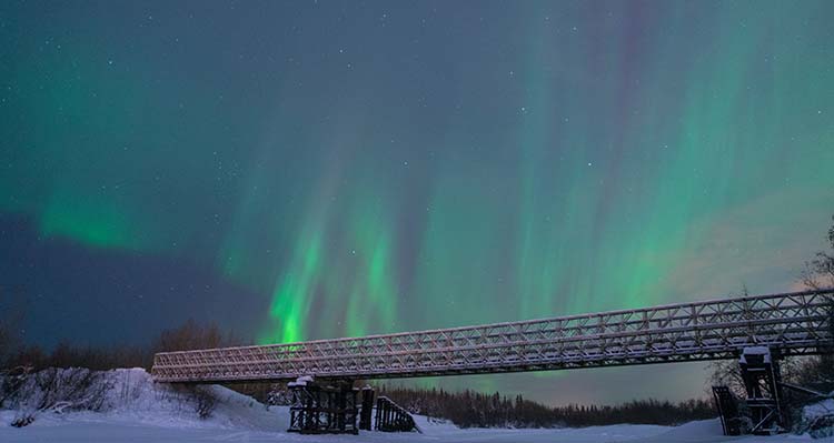 Aurora streaks over a bridge in the Arctic Circle.