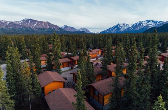 An aerial view of Denali Cabins with the mountains in the background
