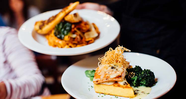 Two dishes being served at a restaurant in close up.