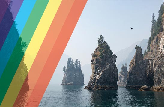 Cliffs rising from the sea, with a rainbow pattern overtop.