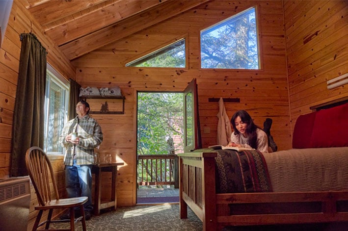 A couple reading and drinking coffee in their ocean view Cabin