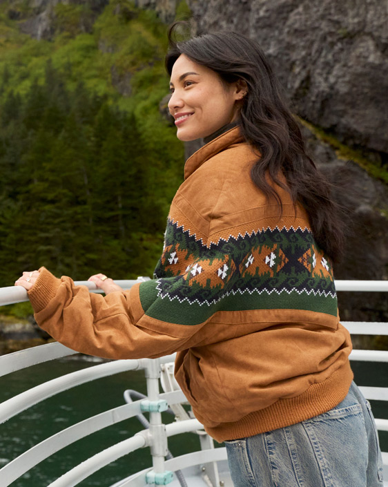 A person standing on the boat deck looking at the view.