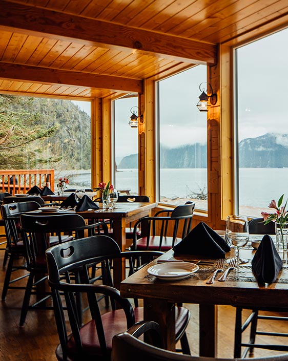 A dining room with large windows overlooking the ocean.