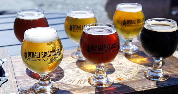 A flight of beer glasses on a table.