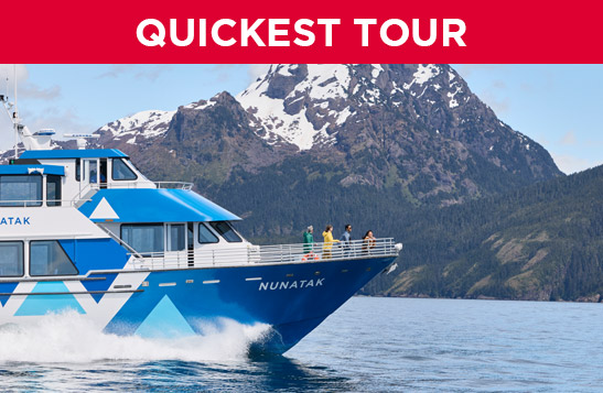 Kenai Fjords Tours boat sailing past a mountain.
