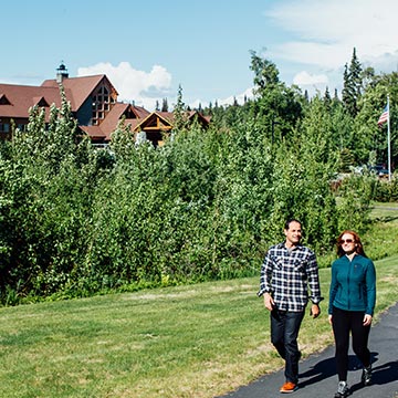 A couple walk outside Talkeetna Alaskan Lodge in the summer.