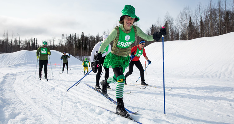 People cross country skiing while dressed up for St. Patrick's Day